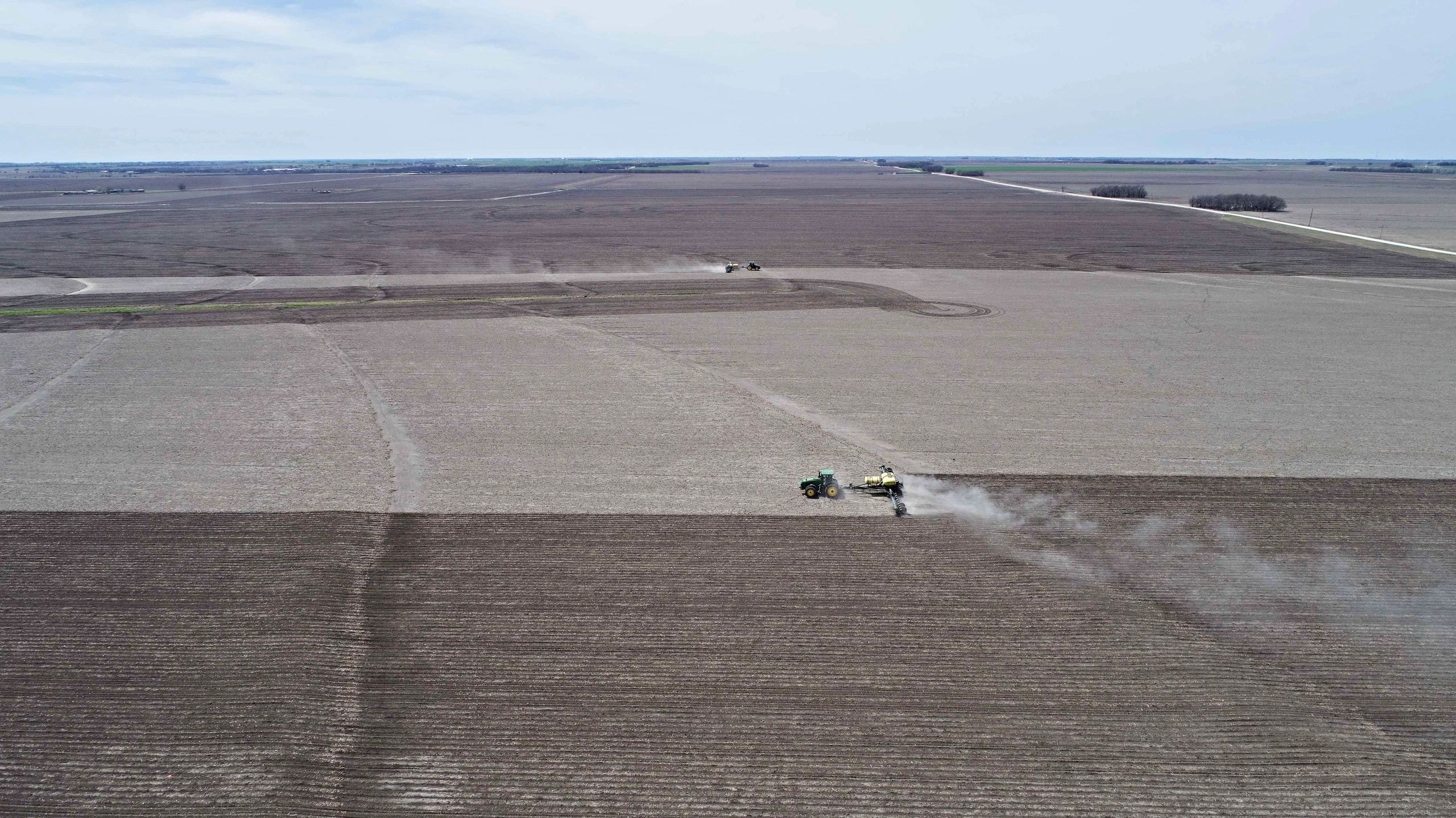 Tractors spraying pesticide vast farmland