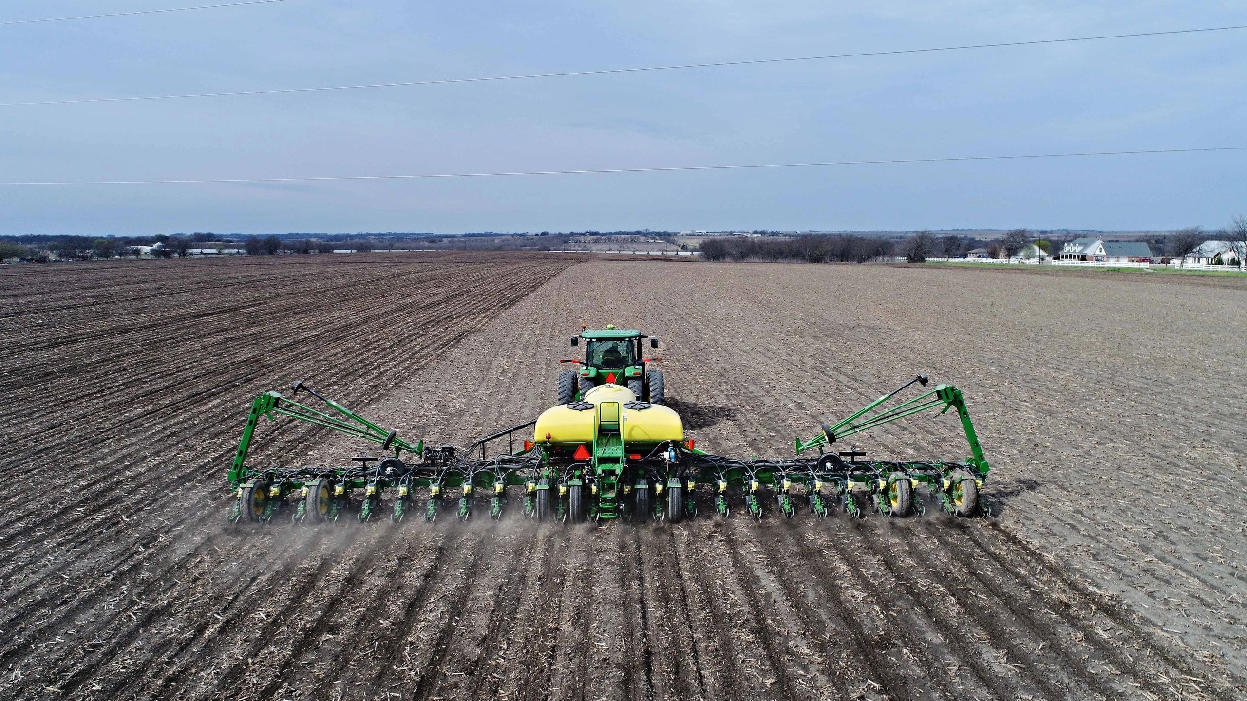 Tractor planting seeds in farmland